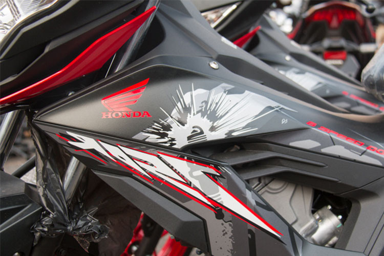 Honda Sonic 150R phiên bản 2018 tiếp tục với dàn áo mới đỏ - đen, năng động và tươi hơn rất nhiều so với phiên bản 2016. Thân xe không còn Logo Sonic như phiên bản trước mà được trang trí bằng các hoạ tiết bắt mắt. Yên xe thiết kế thấp phía người lái và cao dần về phía sau, chiều cao yên là 764 mm - khá dễ dàng sử dụng.