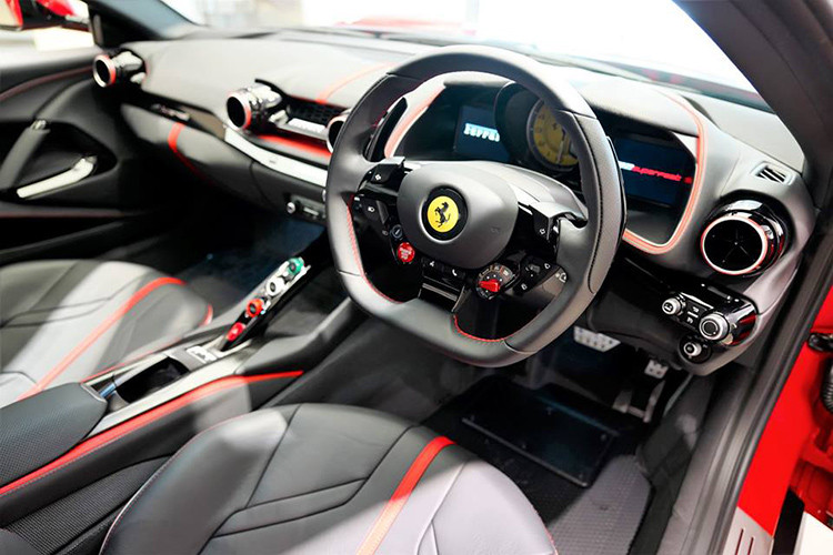 Bước vào bên trong khoang lái, nội thất chiếc siêu xe Ferrari 812 Superfast theo chương trình cá nhân hoá Tailor Made của một đại gia Hồng Kông chào đón khách hàng với ghế ngồi xe đua bọc da cao cấp với đường viền sọc 3 màu xanh lá cây, trắng và đỏ tạo điểm nhấn.