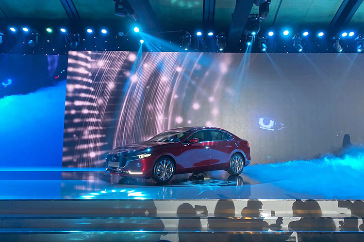 Phần đầu xe của Mazda3 2020 tạo ấn tượng mạnh với thiết kế lưới tản nhiệt cỡ lớn mới. Vẫn mạ crôm nhưng các thanh nan nằm ngang đã được loại bỏ thay vào đó là các nan đa tầng đặt solo tạo hiệu ứng 3D bắt mắt. Hệ thống đèn chiếu sáng trên Mazda3 2020 là dạng full-LED với tính năng tự động điều chỉnh theo góc lái ở cụm đèn chiếu sáng trước. Dải đèn LED định vị được tách riêng ra khỏi cụm đèn chiếu sáng như thế hệ cũ.