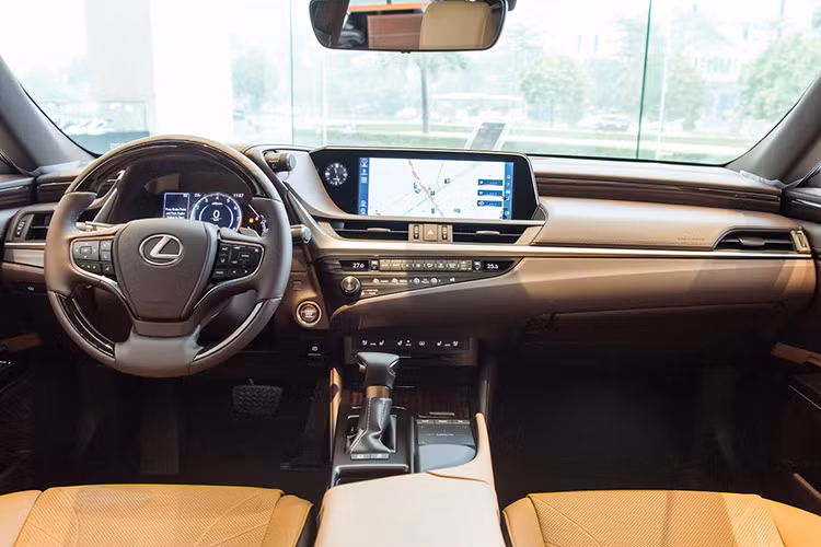 Bước vào khoang lái của Lexus ES 2021 sở hữu vẻ sang trọng của chiếc sedan Nhật Bản không phải kiểu bóng bẩy mà nhẹ nhàng tinh tế, thậm chí có thể dùng từ đơn giản. Cụm điều khiển trung tâm rất ít nút bấm, nổi bật với màn hình giải trí 12.3 inch với tone màu hiển thị chủ đạo là xanh nước biển, đem lại cảm giác êm dịu thư thái.