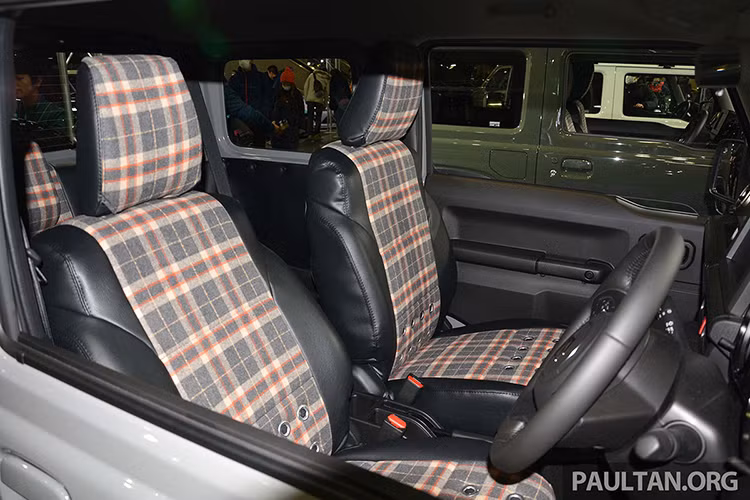 Bên trong chiếc Suzuki Jimny 2019 độ bộ body kit Little G xuất hiện ghế bọc da phối nỉ. Trong đó, phần nỉ được thiết kế kẻ caro và có 3 hàng lỗ khá lạ mắt. Tựa đầu ghế cũng được thiết kế theo phong cách tương tự.