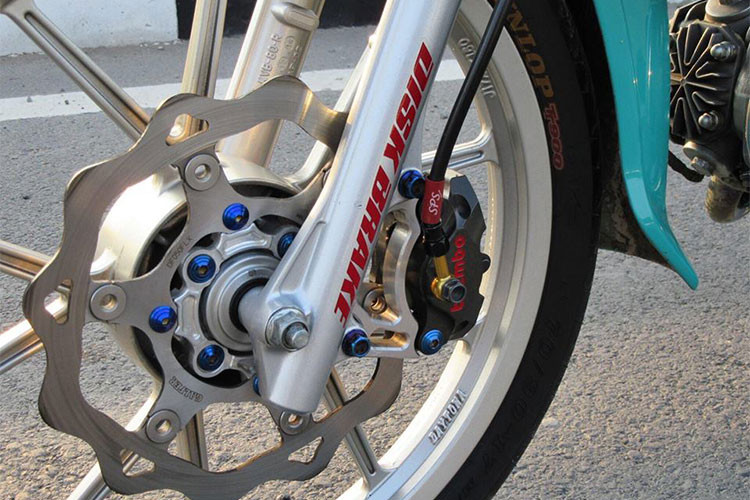 Ở dàn chân trước, chiếc Dream II độ kiểng này được trang bị dây dầu SPS dẫn một lượng dầu nhất định tạo một lực đẩy đến 2 pis tông đối xứng của heo Brembo Biller làm 2 bên bố ma sát vào đĩa Galfer. Phược trước của xe được làm mới ấn tượng hơn so với nguyên bản trước đây.