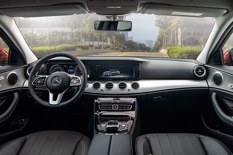 Nội thất xe E180 được ốp nhôm trên táp-lô và ốp gỗ đen trên cụm điều khiển trung tâm. Tay lái đa chức năng 3 chấu thiết kế mới được bọc da nappa với nút điều khiển bằng cảm ứng. E180 vẫn được trang bị màn hình giải trí 12,3 inch sắc nét.