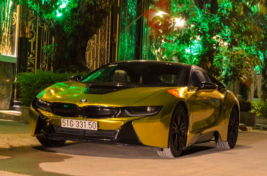 Đến sau cùng là chiếc BMW i8 dán decal crom vàng. Trên thân xe vẫn còn lá cờ Việt Nam khi tham gia diễu hành trước trận chung kết U23 châu Á ngày 27/1. BMW i8 từng gây xôn xao trong giới chơi xe cả nước vào năm 2016 và tạo nên cơn sốt. Tổng cộng gần 30 chiếc được nhập về Việt Nam, đều thuộc diện không chính hãng. Giá trị lúc đầu của mẫu xe này khoảng 7 tỷ đồng.