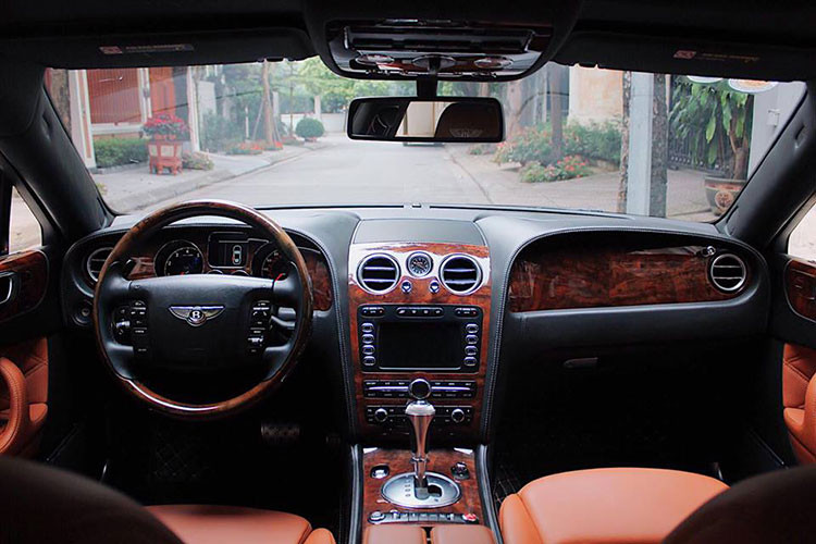 Mở cửa bước vào trong khoang lái, chiếc xe siêu sang Bentley Continental Flying Spur mang ngoại thất màu đen là nội thất bọc màu da bò rất nổi bật đi kèm các chi tiết ốp gỗ thượng hạng được tuyển chọn khắt khe. Thảm sàn và trần xe bọc da cao cấp màu đen với các đường chỉ khâu màu cam nhạt.