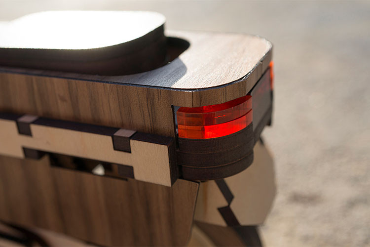 Hệ thống yên xe cũng làm từ gỗ, dưới yên là cốp chưa đồ - tuy nhiên điều thú vị là khối động cơ cũng nằm ở phía dưới yên của chiếc xe gỗ này.