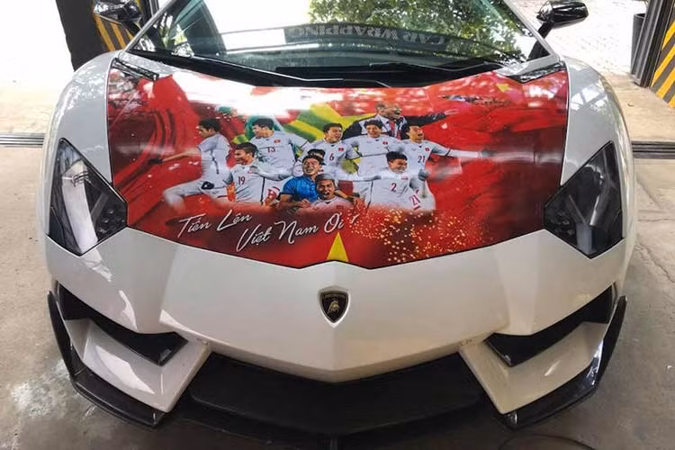 Lamborghini Aventador LP700-4 màu trắng mới tại Sài Gòn này được chủ nhân cho lên băng rôn cổ vũ Olympic Việt Nam trước trận bán kết với Hàn Quốc đã được độ body kit bằng sợi carbon của hãng độ Vorsteiner. Ngoài ra, "siêu bò" này còn được trang bị bộ mâm NV1 của hãng Vossen.