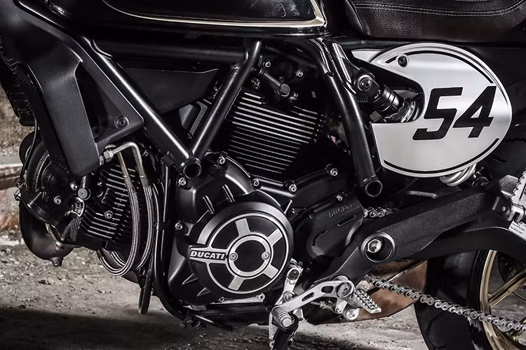Nằm giữa bộ khung của chiếc Scrambler Cafe Racer vẫn là khối động cơ Desmodue hai xi lanh dung tích 803cc, hộp số 6 cấp được làm mát bằng chất lỏng, phù hợp với tiêu chuẩn khí thải EURO 4 hiện nay. Cỗ máy mới này có vỏ bọc được phủ đen "sẹc tông" với thân xe và khung tản nhiệt được gia công chi tiết, kỹ càng.