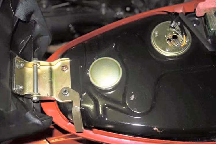 Nắp bình xăng và chốt yên vẫn còn nguyên lớp mạ sáng bóng. 