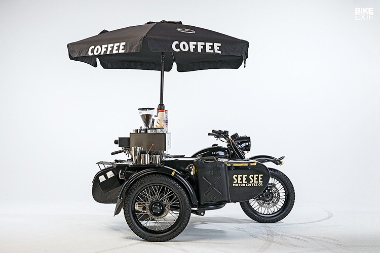 Ural Coffee Cart – See See là phiên bản độ cực kỳ độc đáo với phong cách SiderCar từ mẫu xe Ural cổ điển, đây là một “quán cafe di động” lý tưởng dành cho những người yêu thích xe cộ. Bản độ được thực hiện bởi xưởng độ See See, xe được lắp đặt thêm túi khí an toàn, bồn rửa tay, tủ giữ nhiệt, máy xay cafe, hệ thống cấp điện…Tất cả những trang bị này chỉ khiến bản độ nặng thêm 50kg. Xe vẫn có thể hoạt động một cách bình thường và được dùng để bán cafe di động.