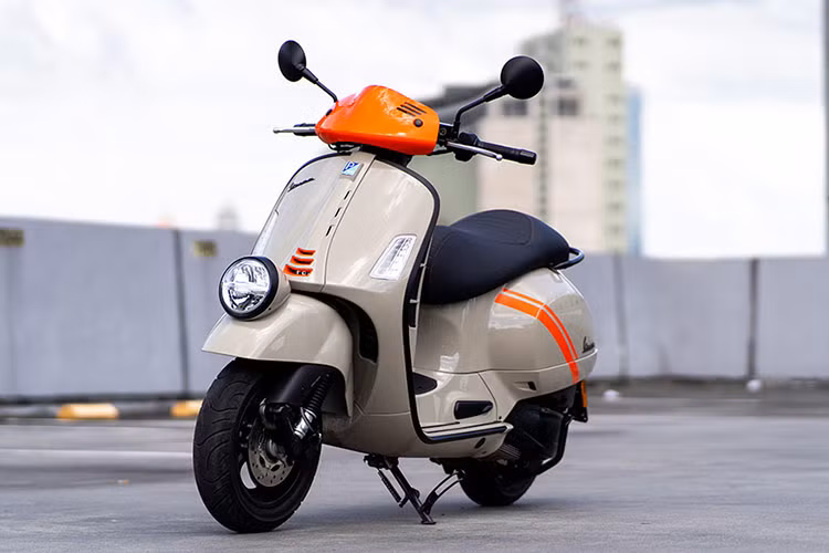 Piaggio vừa giới thiệu Vespa GTV300 2024 mới ra thị trường Nhật Bản. Màu mới này được điêm xuyết với những đồ họa màu cam sáng trên thân xe. Ngoài ra, trên đầu xe, tấm ốp trước và sau xe cũng có các đồ họa màu cam. Cách phối màu này giúp cho Vespa GTV300 hấp dẫn hơn. 