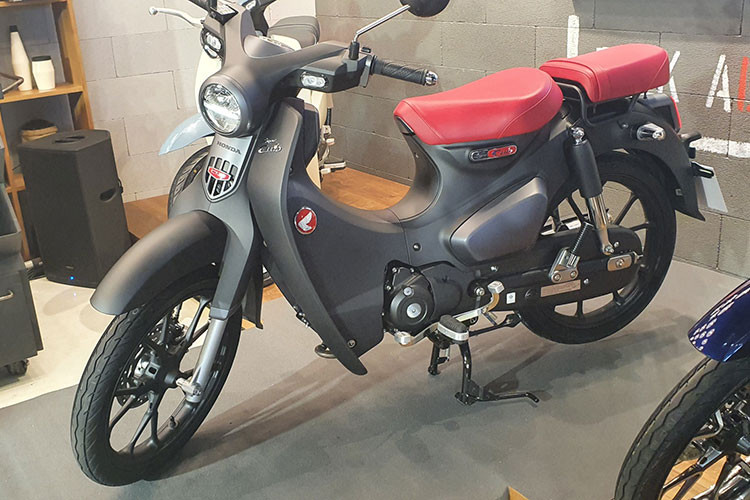 Điểm nhấn đáng chú ý của Honda Super Cub thế hệ mới chính là phiên bản màu Đen mờ mới với dàn áo, bộ vành màu đen mờ lịch lãm và mạnh mẽ. Nổi bật trên đó là bộ yên hai mảnh cùng logo xe màu đổ rất nổi bật.