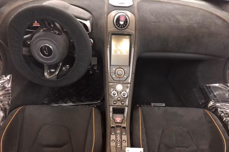 Giống những mẫu siêu xe từ trước tới nay của McLaren, 650S Spider cũng sở hữu cửa mở lật độc đáo. Nội thất của xe được bọc da Alcantara kết hợp cùng các đường chỉ cam may tinh xảo ở ghế ngồi, bảng điều khiển trung tâm, thành cửa hay vô lăng thể thao của xe. Tất nhiên, bên trong khoang lái siêu xe này còn có nhiều chi tiết sợi carbon. 