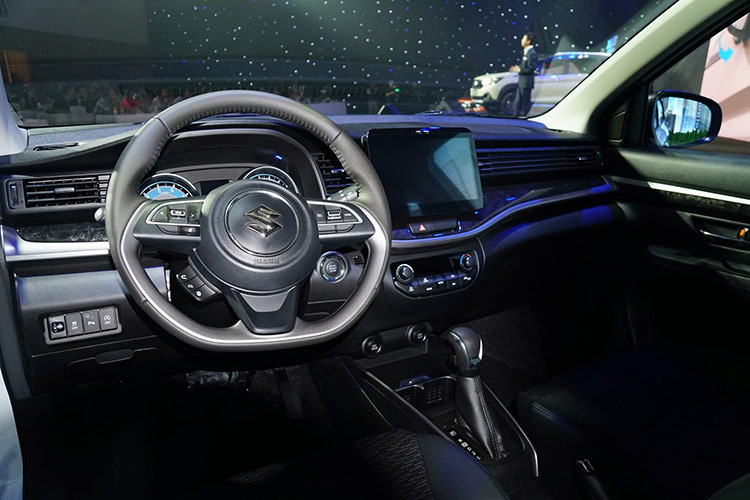 Bên trong xe, Suzuki XL7 Hybrid được trang bị trần xe màu xám nhạt mới thay cho màu be cũ, kết hợp cùng viền trang trí màu bạc liền mạch từ cửa hông, qua khu vực bảng điều khiển và vô lăng. Chi tiết ốp nhựa trang trí trên cánh cửa cũng được đổi mới thành họa tiết vân gỗ mới.