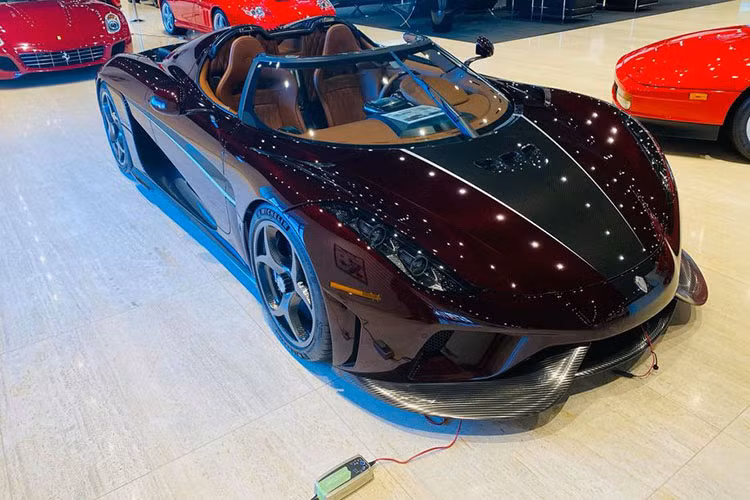 Siêu phẩm Koenigsegg Regera này đúng mang màu đỏ carbon và biển số từ nước bạn Campuchia chính là tên viết tắt của Hoàng Kim Khánh. Như vậy, sau khi đặt biển số xe McLaren Senna là tên vợ, doanh nhân quận 12 đã đưa tên mình vào biển số xe Koenigsegg Regera.
