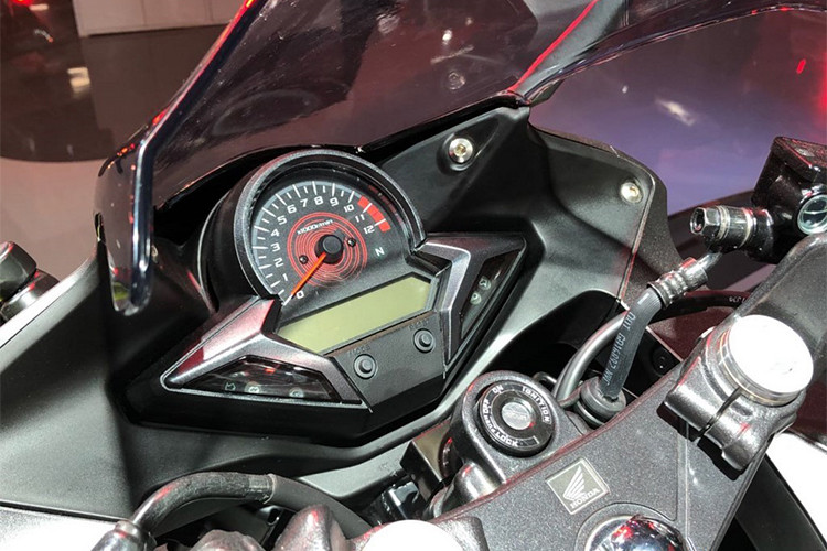 Cùng với đó, cụm đèn pha của Honda CBR250R đã được trang bị hệ thống đèn pha và đèn định vị LED. Bảng đồng hồ của xe thiết kế đơn giản với đồng hồ dạng kim truyền thống đo vòng tua máy, phía dưới là màn hình lcd cỡ nhỏ chỉ tốc độ, thông số, báo xăng... cùng đèn báo.