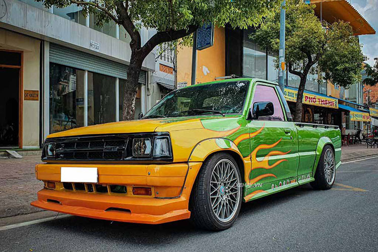 Ở phía sau, hệ thống đèn hậu, ống xả cũng đã được độ lại. Chi tiết cánh gió đuôi lắp thêm ở trên nóc cabin càng làm tăng thêm vẻ độc đáo cho chiếc bán tải cabin đơn. Khoang nội thất của xe về cơ bản vẫn giữ được nguyên thiết kế. Ngoại trừ bảng táp-lô được sơn lại màu xanh lá, gắn vô-lăng và cần số kiểu xe thể thao JDM.