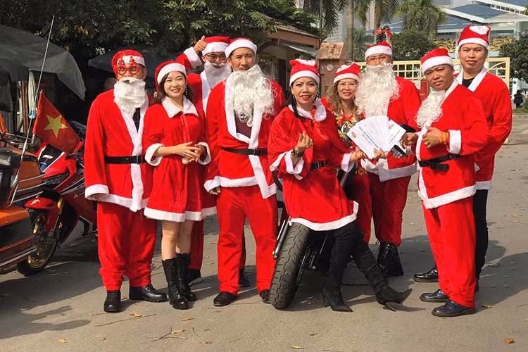 Những ông và bà già Noel mang đến bệnh viện K Tân Triều 60 suất quà, mỗi suất trị giá hơn 500 nghìn đồng bao gồm bánh, sữa và tiền mặt. Nhã Phương (áo đỏ) cho biết năm nào cũng cùng chồng đi tặng quà trong dịp Noel. Mọi khi, vợ chồng Phương đi chiếc xe Sidecar nhưng hôm nay thì chạy một chiếc xe bình thường để tranh thủ đi làm.