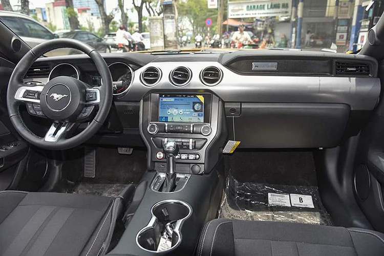 Bên trong nội thất, Mustang 2018 màu cam độc nhất Việt Nam sở hữu một không gian cabin đầy ấn tượng với thiết kế nam tính và mang một màu đen xuyên suốt. Vô lăng kim loại 3 chấu bọc da, tích hợp nhiều phím chức năng hỗ trợ người lái và lẫy chuyển số phong cách thể thao.