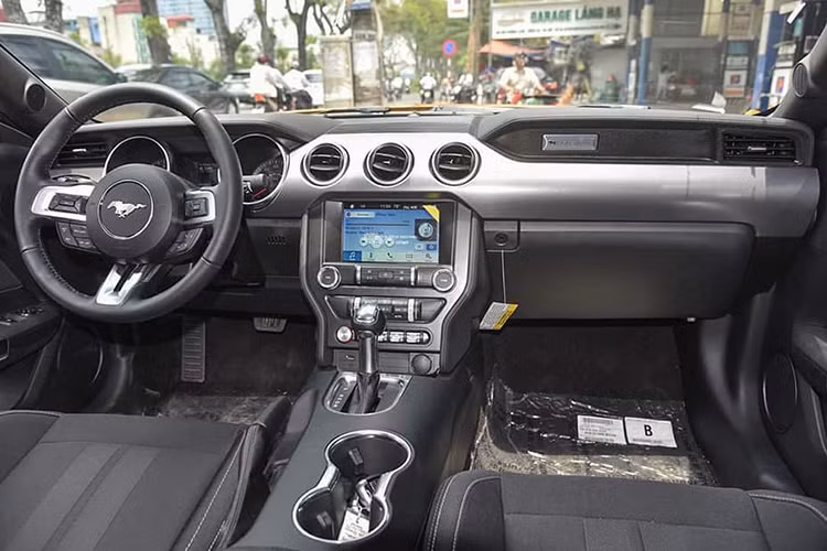 Bên trong nội thất, Mustang 2018 màu cam độc nhất Việt Nam sở hữu một không gian cabin đầy ấn tượng với thiết kế nam tính và mang một màu đen xuyên suốt. Vô lăng kim loại 3 chấu bọc da, tích hợp nhiều phím chức năng hỗ trợ người lái và lẫy chuyển số phong cách thể thao.