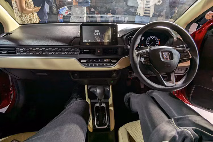 Thay đổi đáng chú ý nhất của Honda Amaze 2025 nằm ở khoang cabin. Bảng táp-lô được thiết kế lại hoàn toàn, màn hình cảm ứng 8 inch hỗ trợ Android Auto/Apple CarPlay không dây, màn hình TFT 7 inch tại cụm đồng hồ. Hệ thống điều hòa tự động được tinh chỉnh, trong khi vô-lăng mới mượn thiết kế từ Honda City.