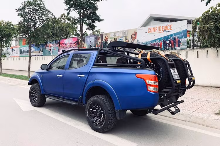 Ngoài ra, chiếc Mitsubishi Triton cũ này còn được trang bị mâm hợp kim thể thao màu đen 17inch, đi kèm lốp xe địa hình và vòm bánh xe mở rộng. Một số chi tiết nhỏ cũng được sơn đen, nhằm tăng diện mạo hầm hố và cá tính, như: thanh chằng đồ trên nóc, hệ thống lốp dự phòng...