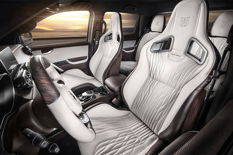 Trần mẫu xe bán tải Mercedes X-Class này cũng đã được phủ bởi da Alcantara. Đi cùng với nó là cách phối màu trắng/ nâu đồng điệu với màu gỗ ốp trên mặt táp lô. Mặt trên và dưới của vô lăng cũng được ốp gỗ này. Cặp ghế trước dạng thể thao đến từ Recaro Sportster.