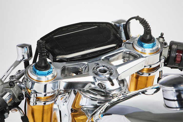 Ở tay lái của xe, cặp tay clip on hạ thấp đậm chất Cafe được điểm bằng cặp tay lái bọc da handmade cùng gương gù cổ điển bắt mắt.