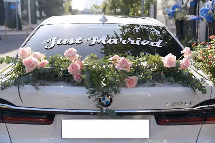Phía đuôi xe BMW 730Li được trang trí hoa hồng và thêm dòng chữ Just Married.