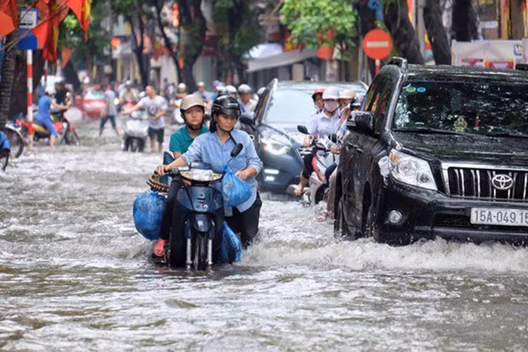 Những chiếc ôtô cũng như xe máy "bì bõm" trên đường ngập nước. Nhiều chiếc xe máy cũng không thể hoạt động được do nước chảy vào.
