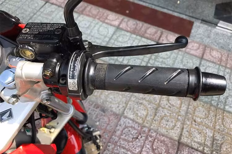 Phần đầu xe của chiếc Nova Dash đắp chiếu này vẫn được chủ nhân giữ nguyên bản với kính núp gió nhỏ, đèn pha chia đôi, xi nhan đút dưới gầm pha... Cùm ga nguyên thủy với tem thông số chính hãng được dán trên ghi đông không thể lẫn vào đâu được của dòng Nova Dash.