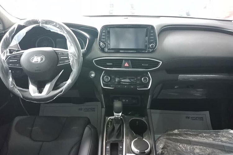 Bên trong của SantaFe 2019 bản tiêu chuẩn thiếu đi vài tính năng cao cấp như đồng hồ công tơ mét kỹ thuật số, thay vào đó là dạng analog truyền thống. Xe cũng chỉ sử dụng phanh tay cơ thông thường chứ không phải là loại phanh tay điện tử đi kèm tính năng Autohold.