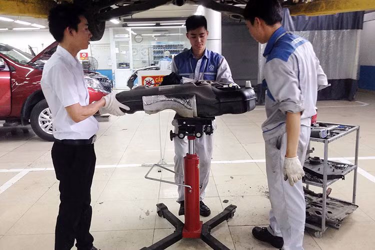 Việc tháo bình xăng liên quan đến các bộ phận như ốp gầm, ống xả... nên bắt buộc phải thực hiện trước. Có thể thấy bình xăng bằng nhựa trên Mazda3 sau khi được hạ khỏi xe.