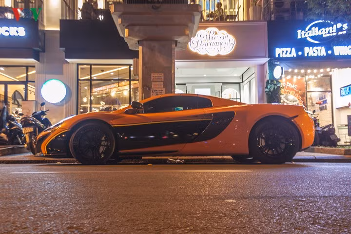 Chiếc siêu xe Mclaren 650S màu cam nổi bật cùng decal kết hợp vàng đen tạo điểm nhấn, khiến chiếc xe trở nên độc đáo hơn.