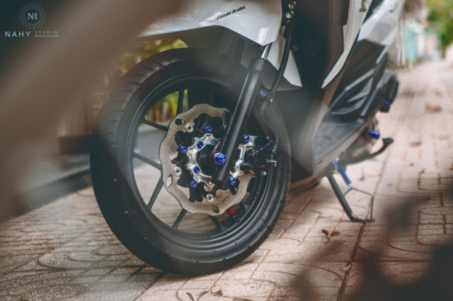 Dàn chân trước của xe được làm mới bằng đĩa thương hiệu Galfer có kích thước 245mm nhưng lại có 5 lỗ ốc, vì vậy phải bắt CNC thêm một thớt lòng bên trong nhằm thay đổi lại pat heo dầu để bố ăn hết được đĩa. Tạo màu sắc thêm bằng dàn ốc đi cùng cốt trước Titan xanh tím.