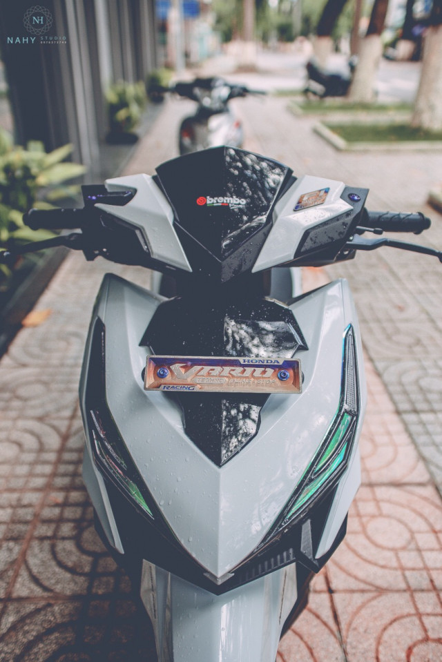 Phần đầu của chiếc xe ga Honda Vario độ này vẫn được giữ nguyên, tuy nhiên cái cách mà chủ xe tạo điểm nhấn cho nó quả thật là rất tinh tế bao gồm bộ viền chóa đèn trước - bản biển số được làm bằng chất liệu nhôm được CNC sau nó tạo màu bằng cách khò nóng lên màu khá lạ.
