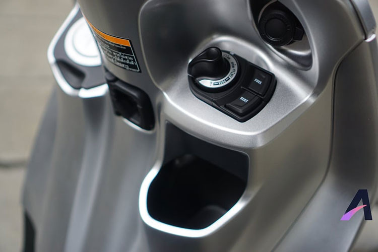 Về mặt tiện ích, Yamaha Grande Hybrid 2018 tiếp tục sử dụng ổ khóa 5 trong 1 đối với phiên bản thường, phiên bản ABS của xe sẽ được trang bị hệ thống khóa thông minh Smart Key. Nắp bình xăng của xe được bố trí cao ở phần yếm xe, giúp người dùng đổ xăng mà không cần xuống xe.