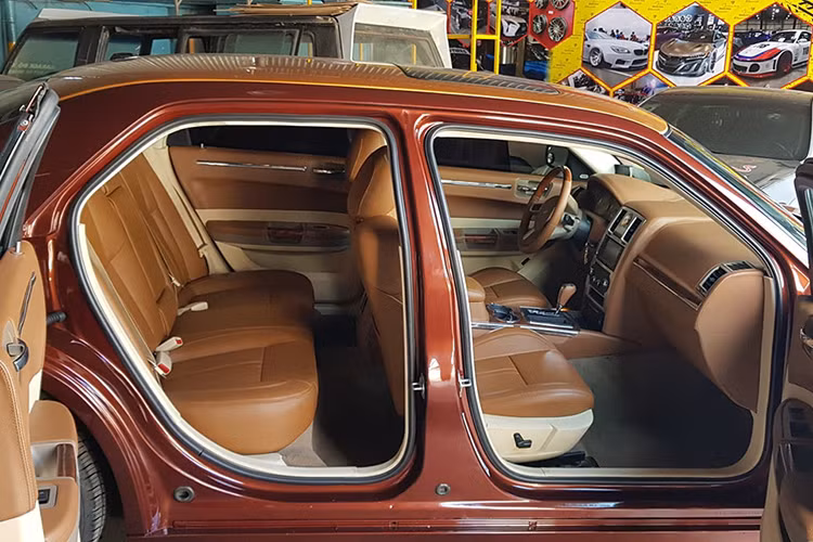 Bên trong nội thất, chiếc Chrysler cũ độ xe sang Phantom sở hữu không gian cabin sang trọng với tông màu nội thất chủ đạo là màu nâu da bò. Ngoài ra, gần như toàn bộ không gian cabin này cũng đều được bọc da, ốp gỗ với một số chi tiết bọc cả carbon lạ mắt.