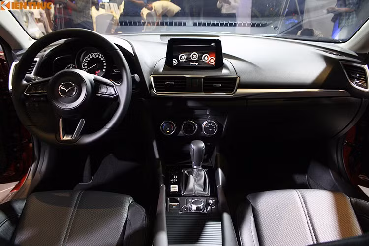 Bên trong nội thất của Mazda 3 phiên bản 2018 ít thay đổi về tổng thể mà tập trung nâng cấp ở một số chi tiết quan trọng. Vô-lăng thêm điều khiển hành trình cruise control. Đồng hồ trung tâm hiển thị vòng tua dạng analog trên màn hình LCD thay vì tốc độ như phiên bản trước. Phanh tay điện tử cũng được thay thế cho phanh tay.