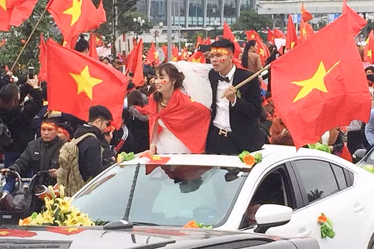 Cô dâu mặc thêm "áo rét" chính là Quốc kỳ và cùng chú rể mở cửa sổ trời, mừng đội tuyển trở về. Đám cưới đặc biệt này cũng đã thu hút được rất nhiều sự chú ý từ phía những cổ động viên trên đường phố Hà Nội.