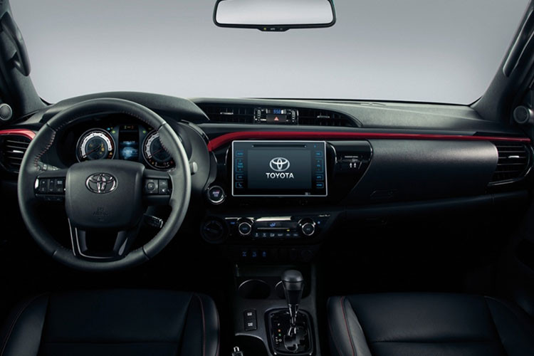 Phía trong nội thất của chiếc xe bán tải này đã được thay đổi khá nhiều: ghế bọc da có đường chỉ đỏ may nổi, logo GR thêu trên tựa đầu hàng ghế trước, phù hiệu GR cùng với số thứ tự xe bằng kim loại đính phía sau cần số, nút khởi động và thảm trải sàn có logo GR.