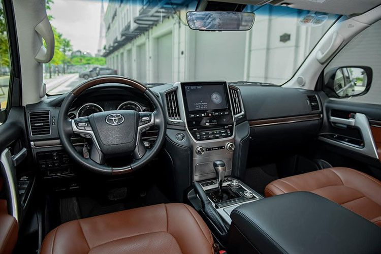 Bên trong nội thất, Toyota Land Cruiser chính hãng và nhập Mỹ về thẩm mỹ không khác nhau. Theo đó, xe SUV này vẫn có bảng táp-lô sử dụng vật liệu da và ốp gỗ cao cấp, trung tâm bảng táp-lô là màn hình giải trí 10,4 inch, cụm điều khiển được mạ bạc và nhiều chế độ vận hành được thiết kế ở khu vực này. Tuy nhiên, điểm hạn chế của Toyota Land Cruiser dù có giá khá cao nhưng vẫn chỉ là phanh tay dạng cơ. 