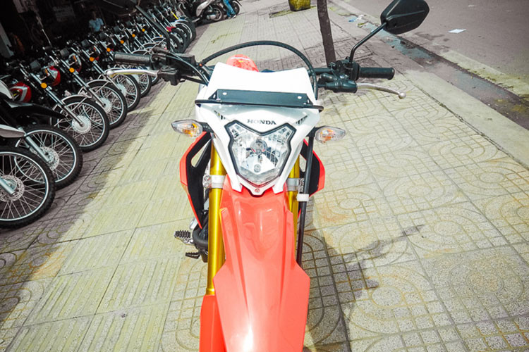 Cụ thể, ở phần đầu hãng xe máy Honda đã thiết kế cho CRF150 với đèn pha hình kiên kèm các đèn xi-nhan hai bên cùng ốp bảo vệ kiêm cả gió. Tuy nhiên các đèn này vẫn sử dụng bóng sợi đốt halogen thay vì đèn LED như nhiều mẫu xe mới đang bán ra thị trường hiện nay.