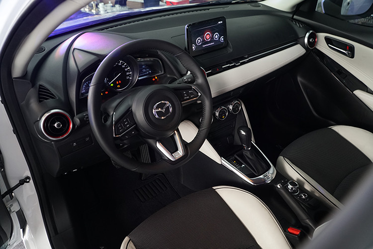 Bên trong, thiết kế vô-lăng trên Mazda2 đời 2018 cũng được lấy cảm hứng từ những người anh em Mazda CX-5, Mazda6, Mazda3 nên trông góc cạnh, mạnh mẽ hơn. Xe cũng đã được tích hợp 2 tính năng khá thú vị là lẫy gẩy số sau vô-lăng và hệ thống kiếm soát hành trình Cruise Control. Đây là hai tính năng khá hữu dụng nhưng lại hiếm khi xuất hiện trên một mẫu xe hạng B như Mazda2.