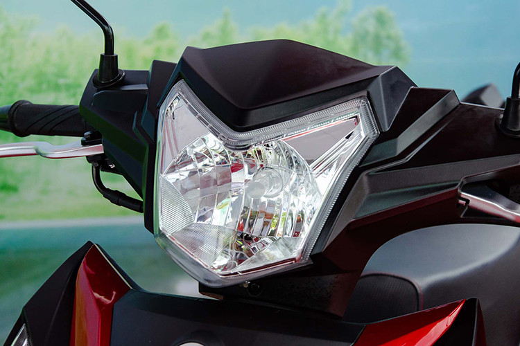 Nổi bật trên mặt nạ là cặp đèn xi nhan và định vị dạng LED có thiết kế sắc sảo, đáng tiếc là đèn pha vẫn ở dạng halogen truyền thống. Thiết kế mặt đèn pha dường như là sự kết hợp "nhấn nhá" giữa hai đối thủ cùng phân khúc hiện nay là Exciter 150 thế hệ cũ và Honda Winner 150.