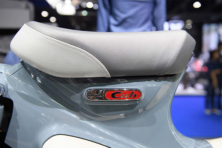 Bên dưới yên xe là logo Super Cub được thiết kế đẹp mắt với các mảng sơn đỏ trên nền mạ chrome. Cốp xe màu trắng mang đậm phong cách của những chiếc xe Cub C100 đời 1968 từng lăn bánh tại Việt Nam.
