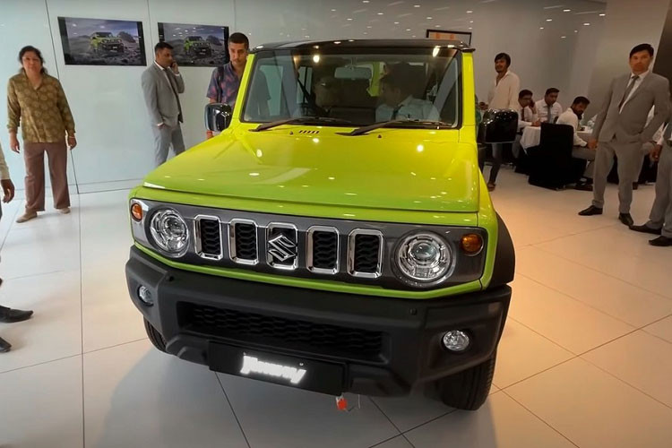 Ngoài kích thước lớn hơn và có thêm 2 cửa bên sườn, Suzuki Jimny 5 cửa vẫn giữ nguyên thiết kế như phiên bản 3 cửa. Xe cũng có các cột thẳng đứng, những bề mặt bằng phẳng, đèn pha tròn trịa, lưới tản nhiệt với nan nằm dọc, lốp off-road hầm hố, ốp cua lốp mở rộng và lốp dự phòng nằm trên cửa cốp sau.