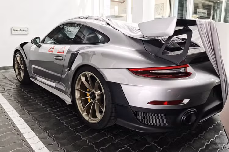 Chiếc siêu xe Porsche 911 GT2 RS được vận chuyển từ TP HCM ra Hà Nội bằng xe lồng chuyên dụng. Ngoại thất xe được bọc đề-can bảo vệ toàn thân và chỉ để lộ ra bộ vành cá tính. Sau khi có mặt tại showroom mới của hãng tại Hà Nội, siêu xe này nhanh chóng được bóc lớp đề-can bảo vệ để lộ hoàn toàn những chi tiết đầy mạnh mẽ.