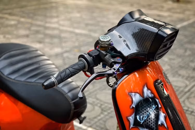 Đáng chú ý là dàn đầu được cắt gọn gàng lại sau đó được ốp Carbon Fiber để làm điểm nhấn. Xe sử dụng đồng hồ điện tử đến từ thương hiệu Sip đa chức năng tương tự như dòng Koso của các mẫu xe độ khác hiện nay.