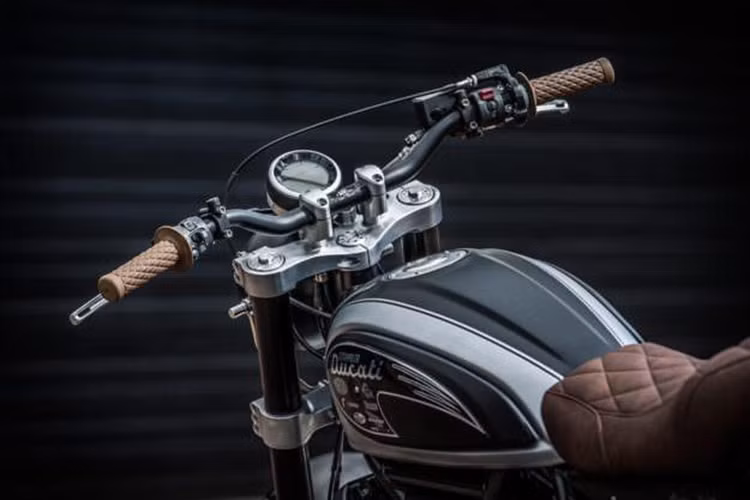 Ngoài ra, chắn bùn trước và đầu đèn của chiếc Ducati Scrambler độ cũng được thiết kế riêng với giá đỡ hoàn toàn mới. Dàn ghi đông LSL được gắn vào trục đỡ do D&amp;O sản xuất và nối với cặp tay cầm của Biltwell Inc. Cặp đèn xi nhan nhỏ và đuôi xe do chính D&amp;O thiết kế.